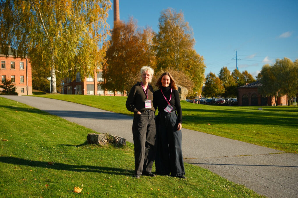 Two people on a batch of grass next two a foot path smiling at the camera, the authors of the post are depicted
