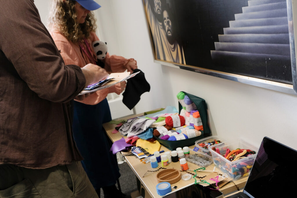 Two people in front of a table with crafting materials on it